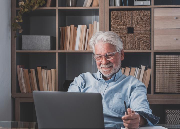 Person sitting in front of their computer, smiling.